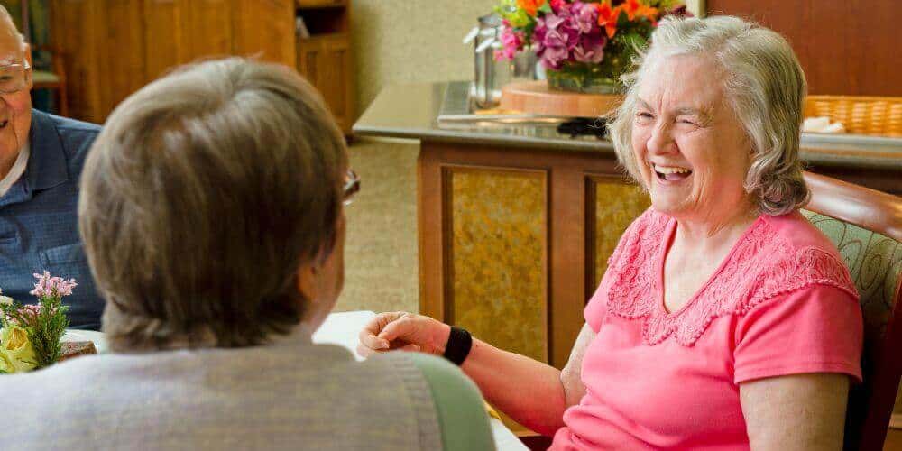 residents laughing together in the dining room